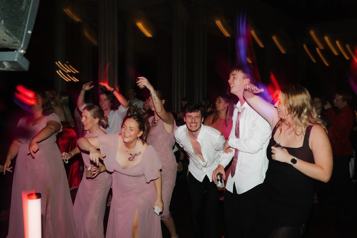Guests dancing with neon light trails across the floor
