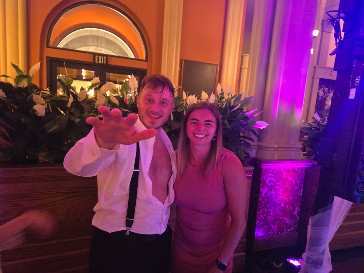 Candid celebration moment with pink stage lighting on classical columns
